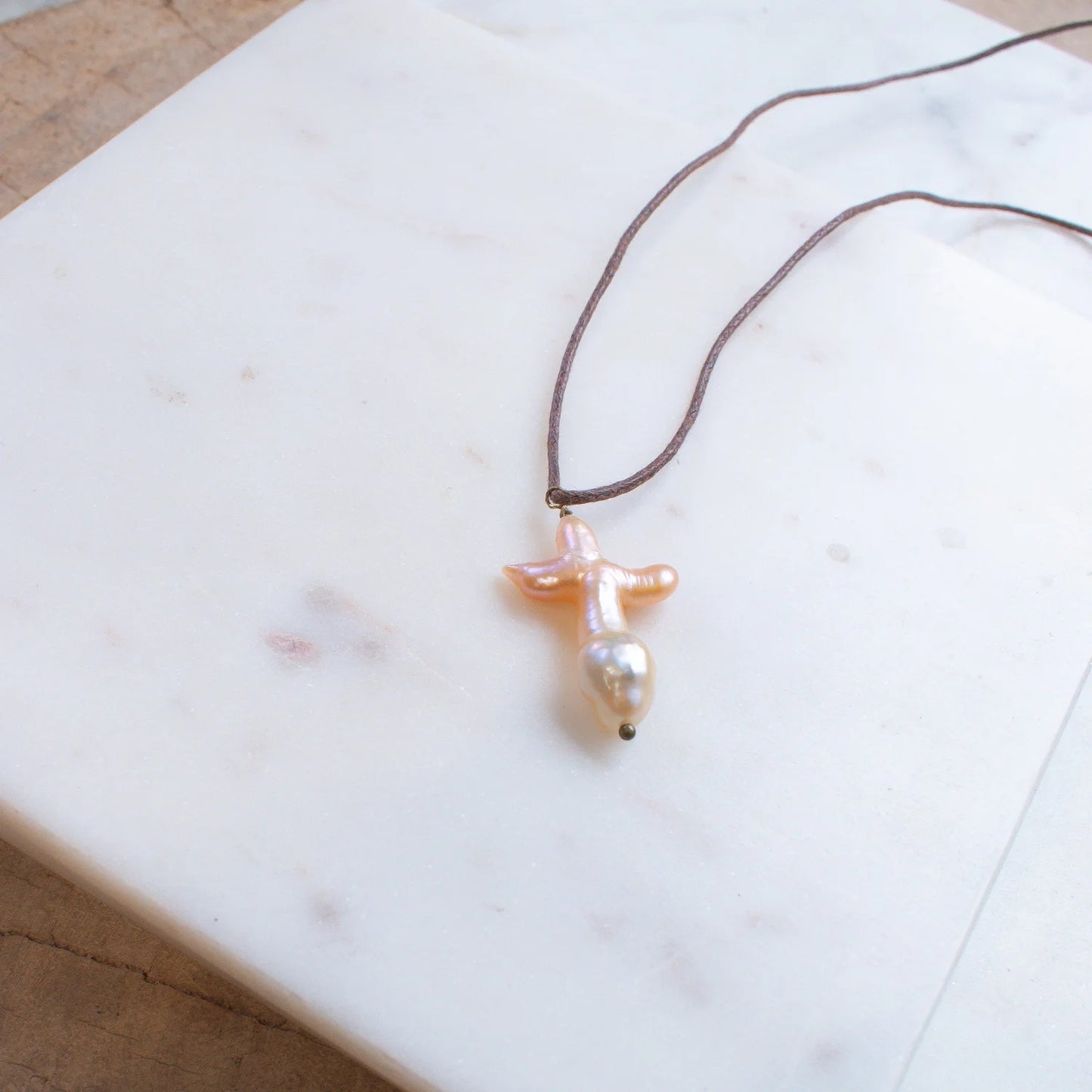 The SOLENE Pearl Cross Necklace on Brown Cord