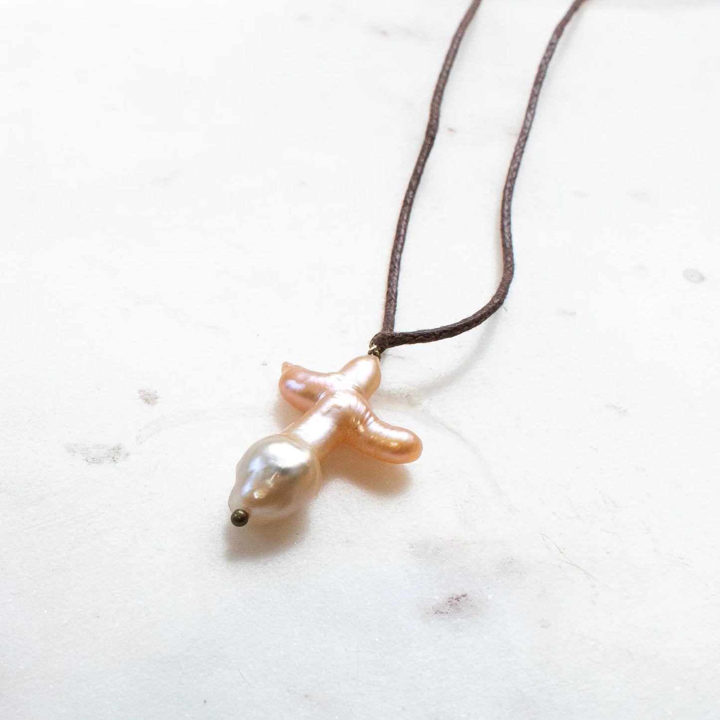 The SOLENE Pearl Cross Necklace on Brown Cord